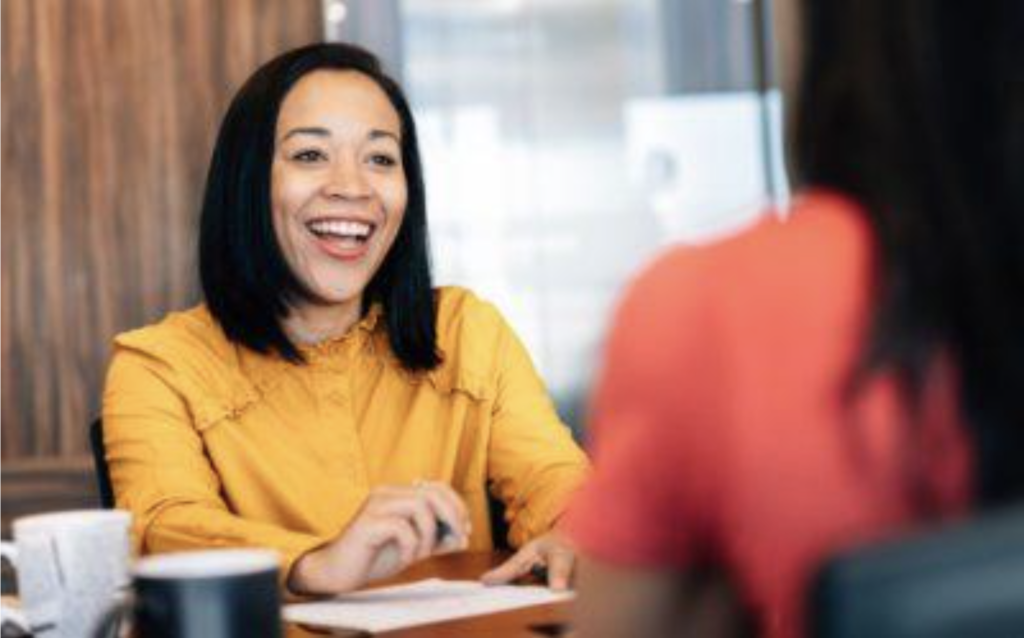 Business woman smiling while sitting at a table